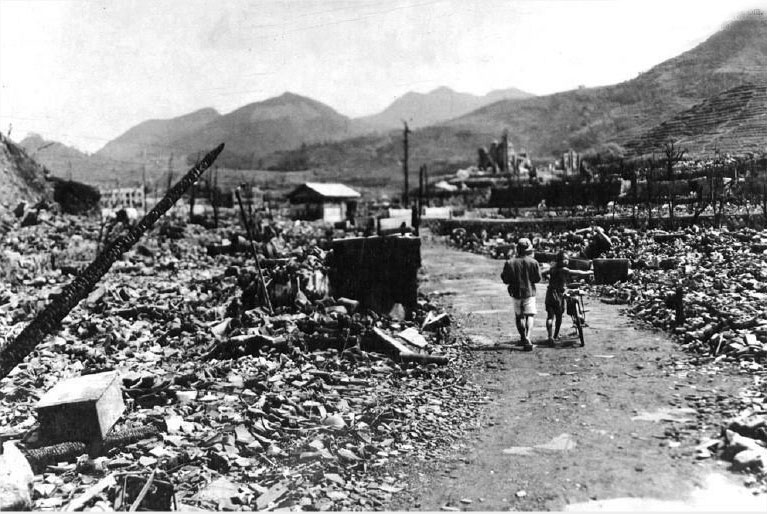 原子弹摧毁长崎城区大部后不久,人们走过烧焦的废墟.