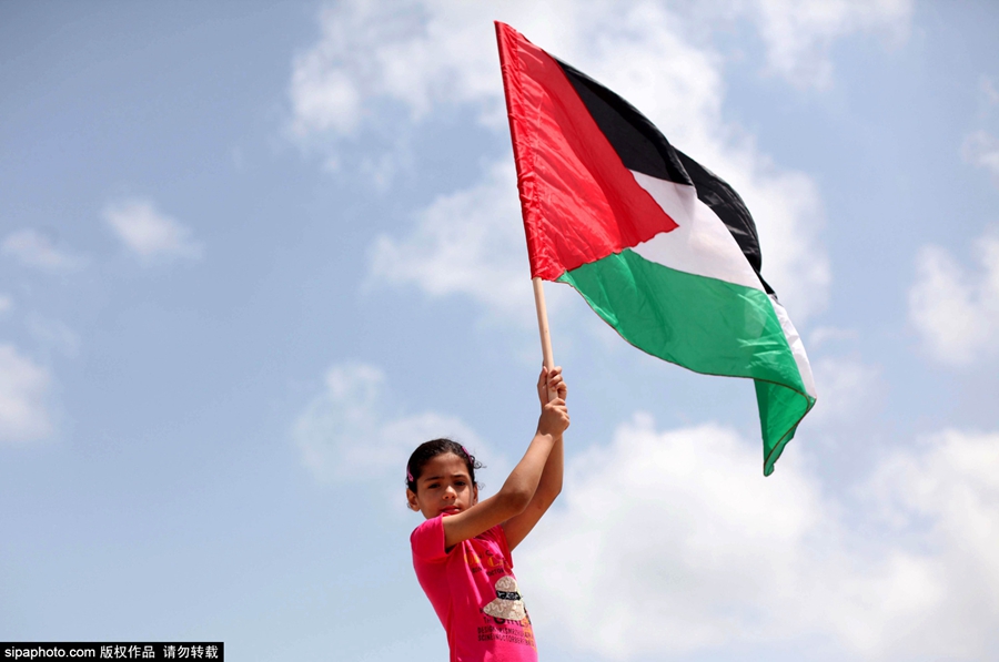 当地时间2015年6月28日,巴勒斯坦加沙地区,巴勒斯坦儿童举标语和国旗
