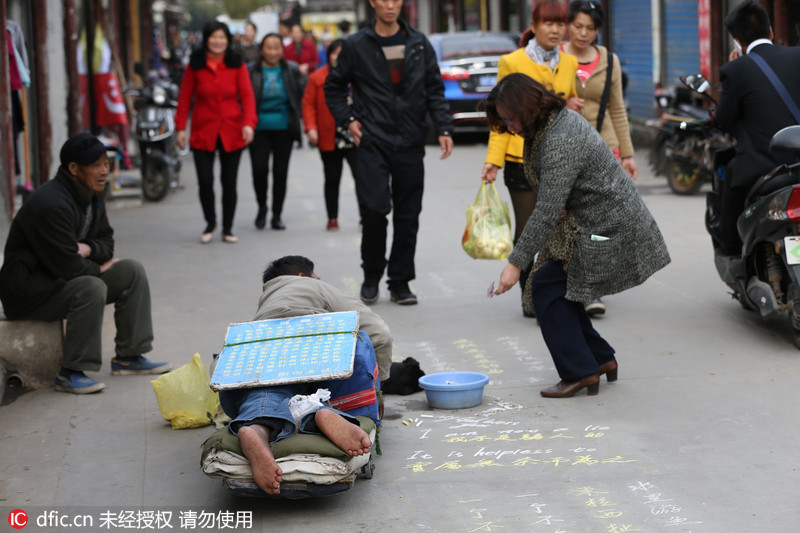 3 上海街头"瘫痪哥"粉笔书写中英文乞讨获同情