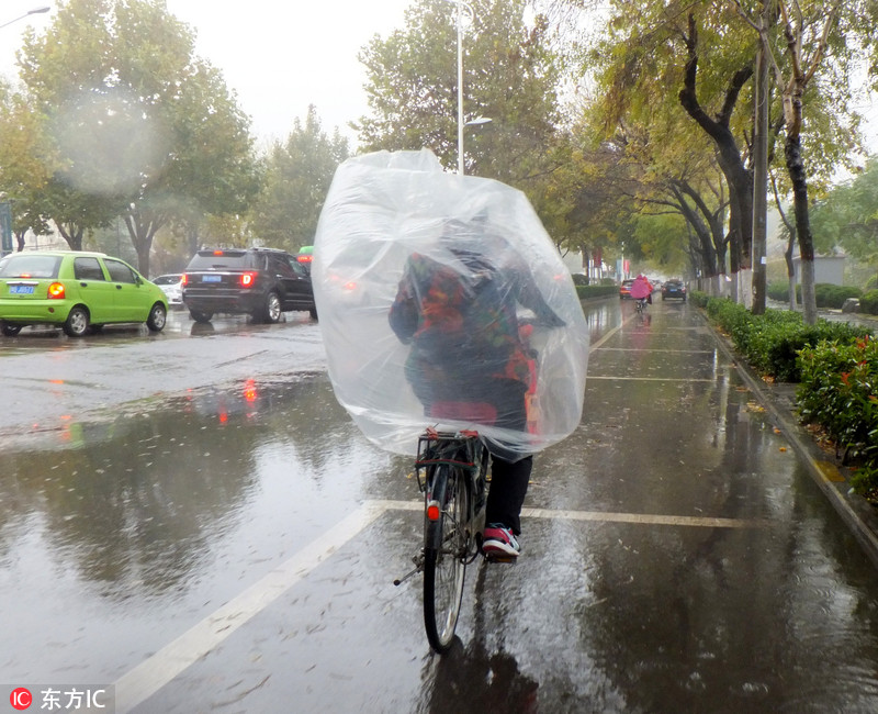 3 开封街头现骑车"牛人 大塑料充当雨衣