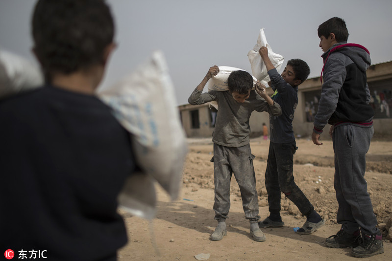 伊拉克逃离战火儿童 小肩膀扛救济粮撑苦难人生
