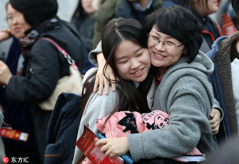 韩国高考结束考生兴高采烈出考场与家人激动拥抱