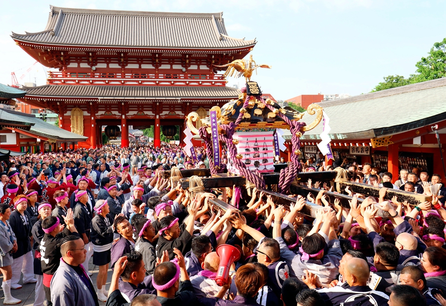 日本东京庆祝三社祭众人着古装合抬神舆