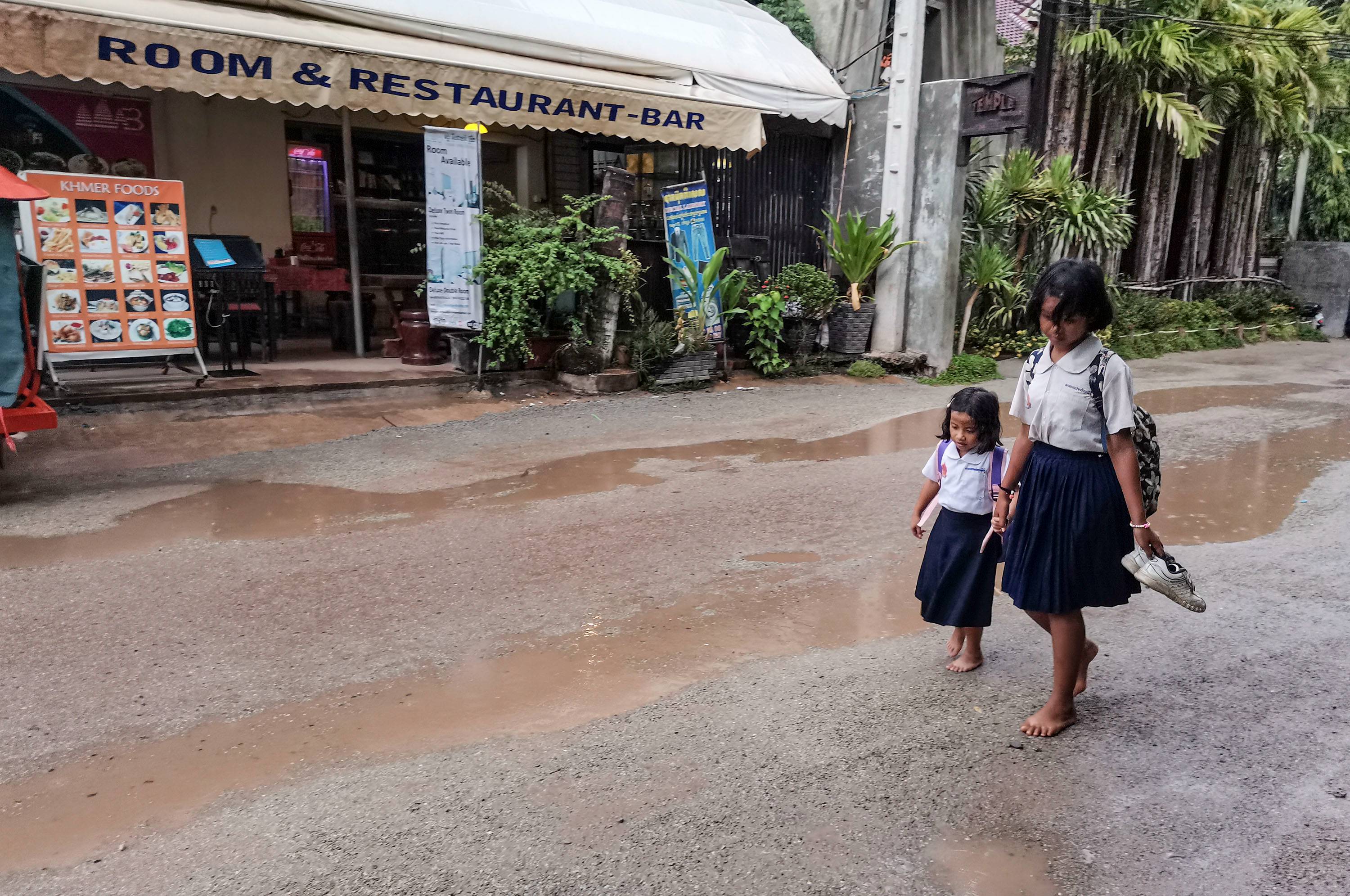 4 柬埔寨暹粒雨中街头 女学生怕湿鞋光脚走泥路