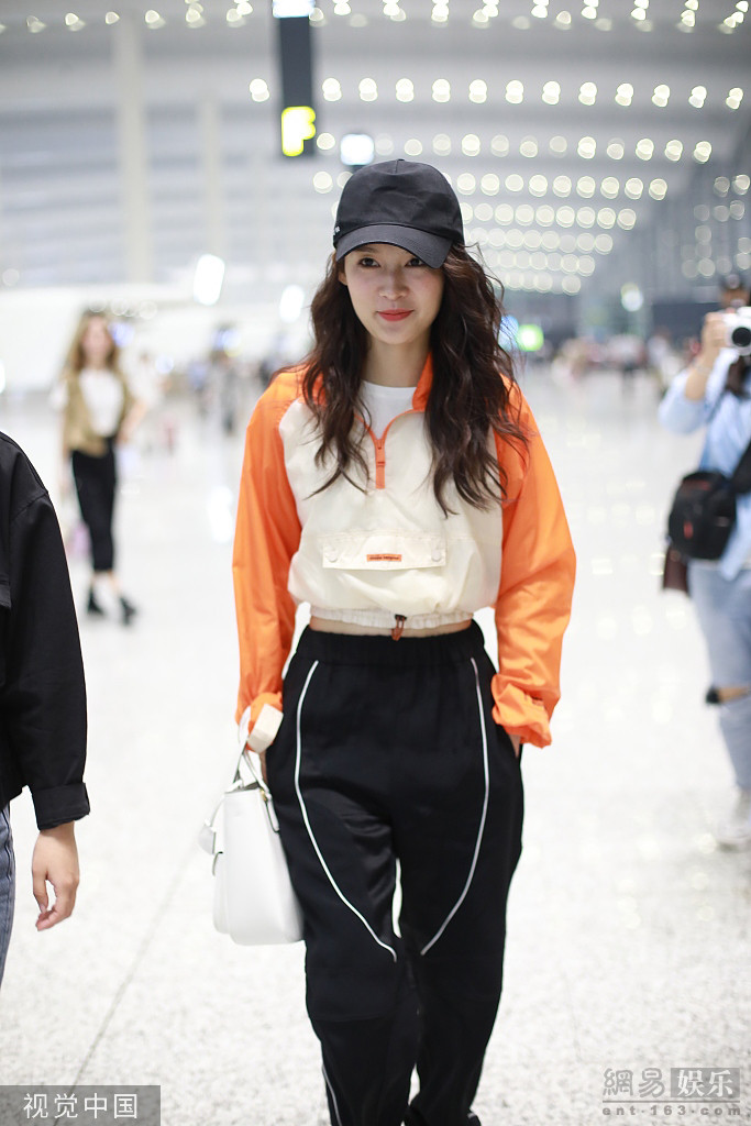 李沁戴鸭舌帽少女感十足 穿橙色运动衣秀腰