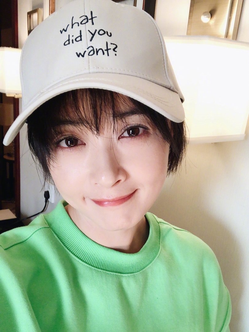 蒋欣短发造型妆容精致 绿卫衣棒球帽出镜一脸甜笑