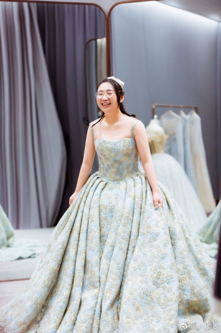 傅首尔试穿婚纱风格百变 丈夫在旁照相甜蜜恩爱