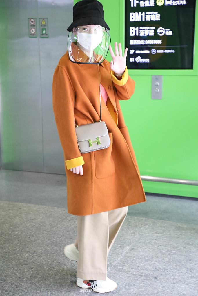 张萌穿黄色大衣现身机场 热情打招呼心情靓