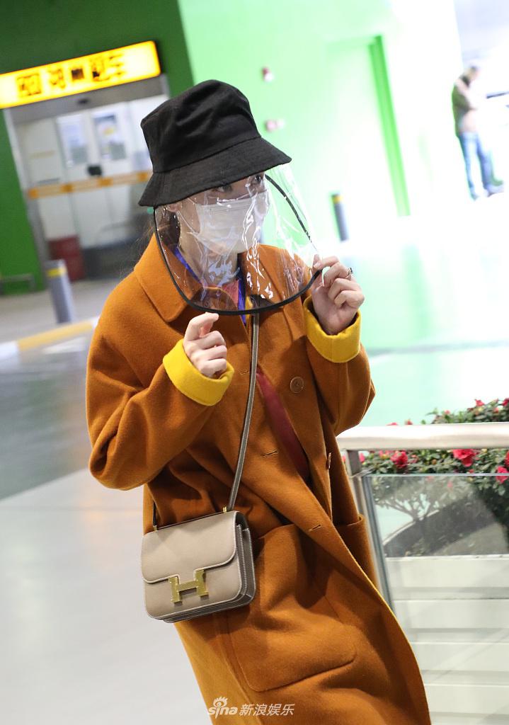 张萌穿黄色大衣现身机场 热情打招呼心情靓