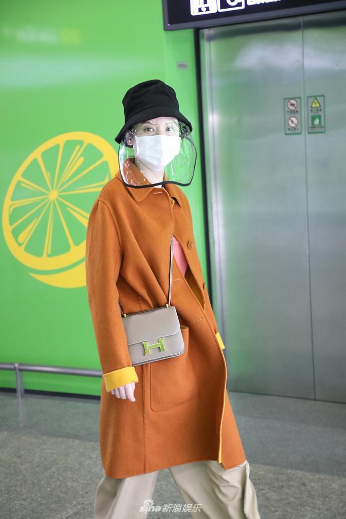 张萌穿黄色大衣现身机场 热情打招呼心情靓