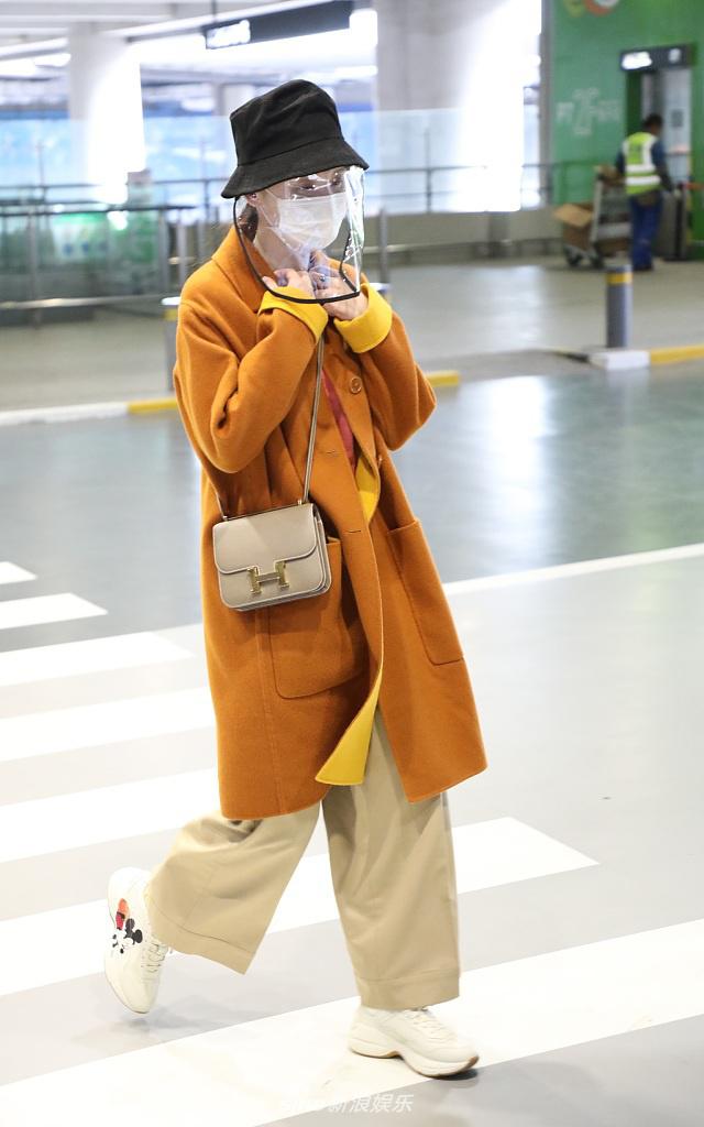 张萌穿黄色大衣现身机场 热情打招呼心情靓