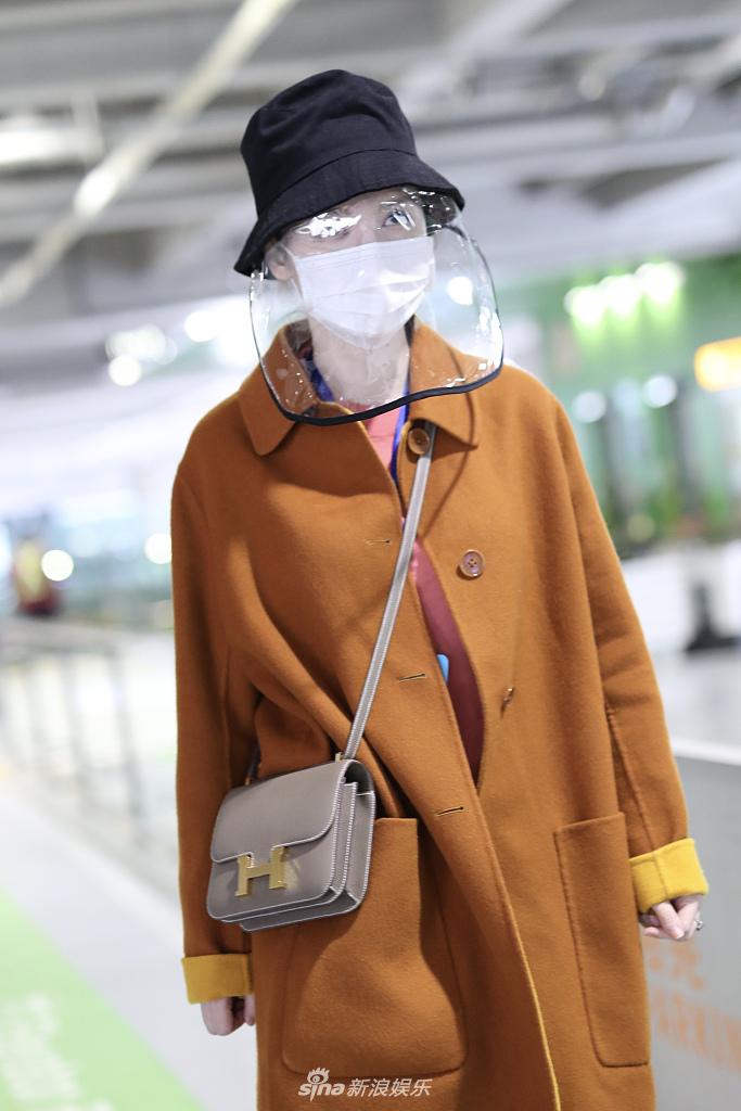 张萌穿黄色大衣现身机场 热情打招呼心情靓