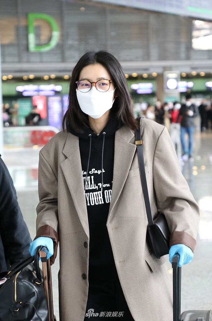 刘雯穿格纹西装英姿飒爽 双手推行李气场全开