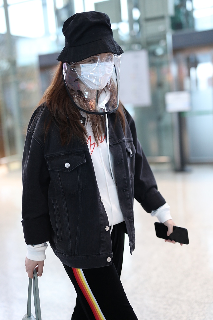 张萌戴黑色渔夫帽现身机场 猫咪手机壳暴露少女心