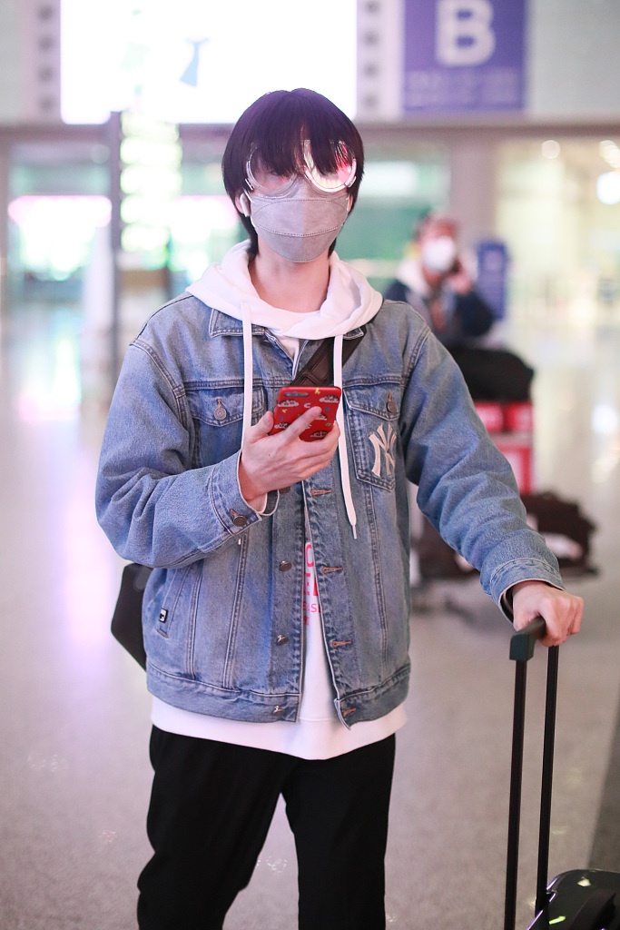 连淮伟亮相机场个性眼镜吸睛 蜡笔小新手机壳暴露少男心