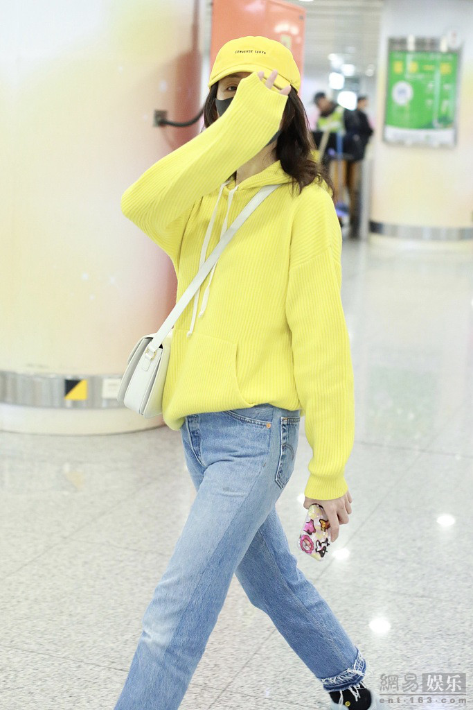 王鸥穿黄色卫衣现身机场 回眸甜笑挥手比V