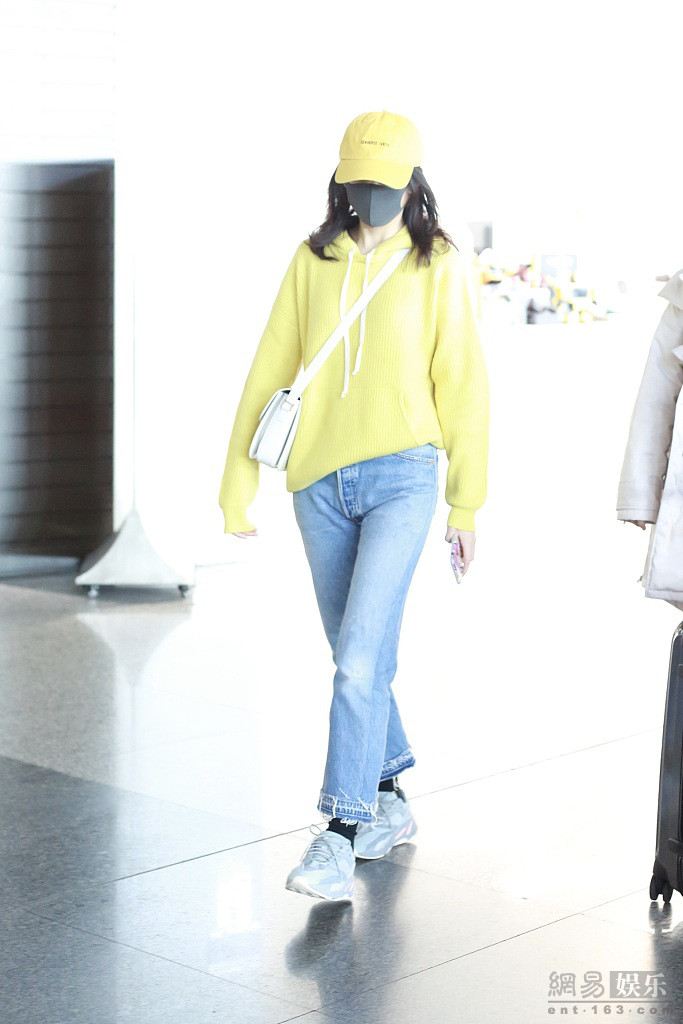 王鸥穿黄色卫衣现身机场 回眸甜笑挥手比V