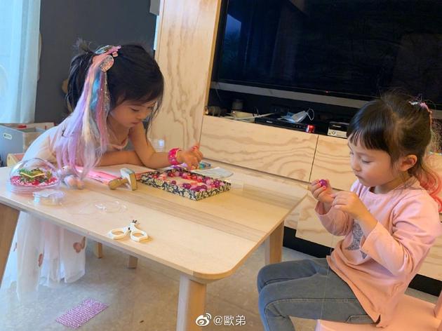 欧弟晒两个女儿睡前萌照 姐妹俩认真摆弄玩具