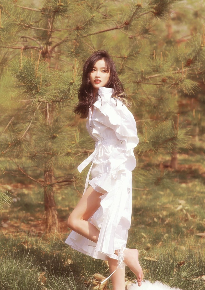 吴宣仪赤脚踏春画面唯美 白衬衫裙配红唇妆尽显朦胧梦幻