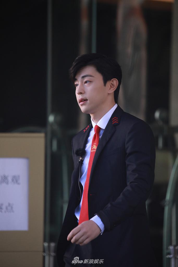 邓伦穿黑西装身材挺拔 扎红色领带侧颜帅气