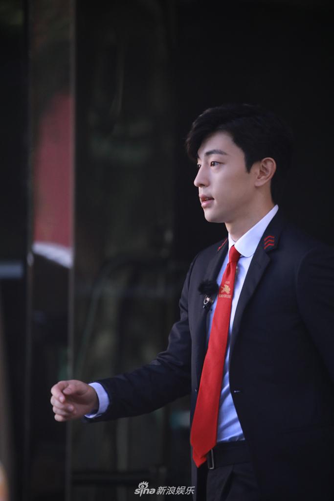 邓伦穿黑西装身材挺拔 扎红色领带侧颜帅气