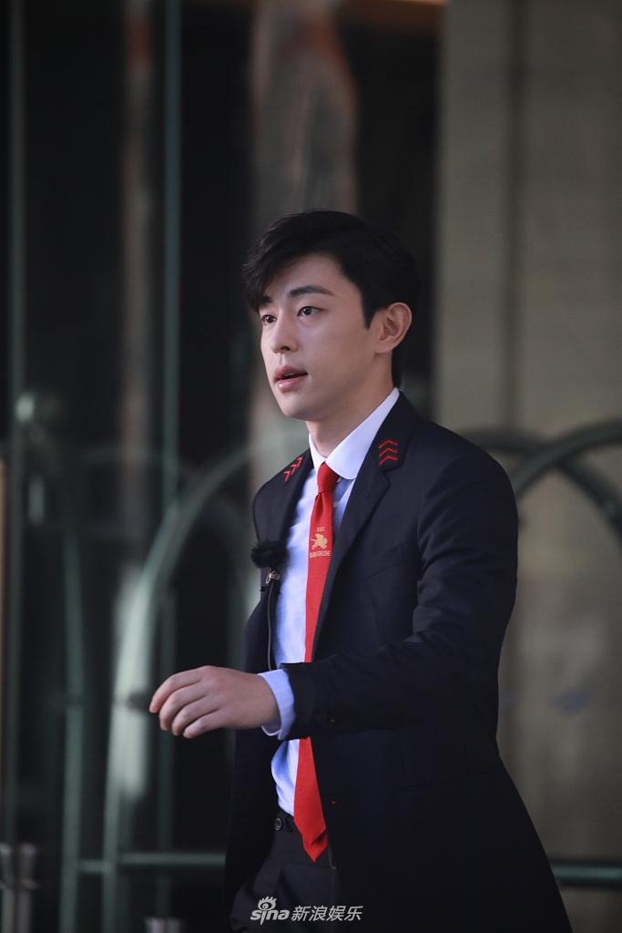 邓伦穿黑西装身材挺拔 扎红色领带侧颜帅气
