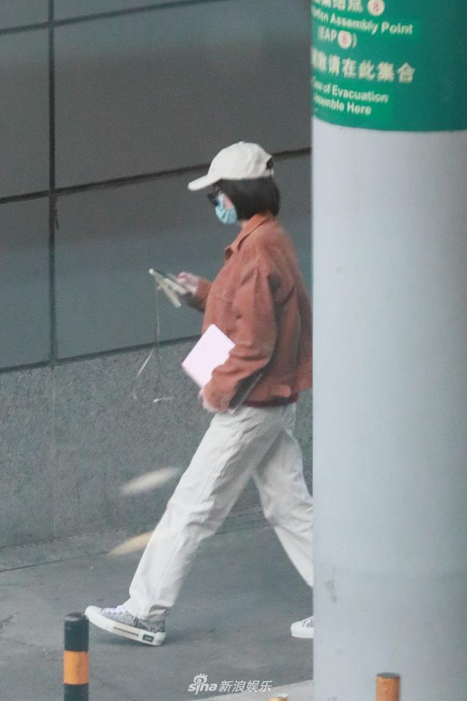 张雪迎穿橘色外套现身机场 一路低头玩手机十分悠闲