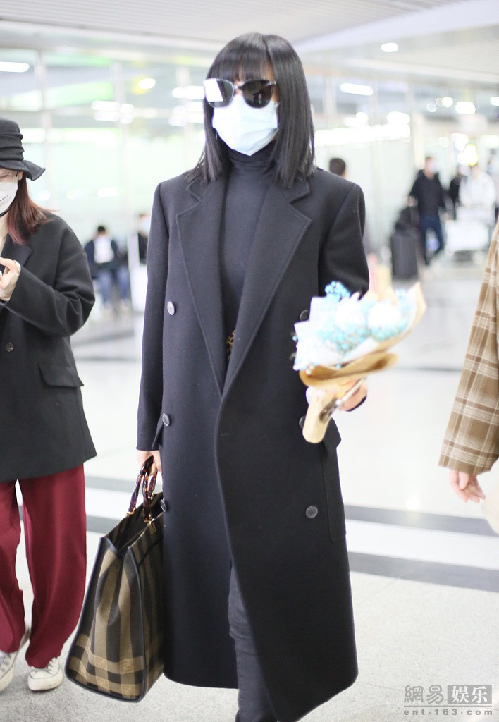 谭卓穿黑色风衣气场十足 机场获粉丝送花心情好
