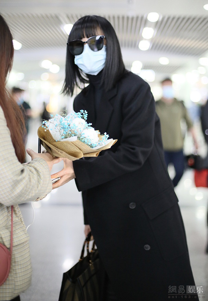 谭卓穿黑色风衣气场十足 机场获粉丝送花心情好