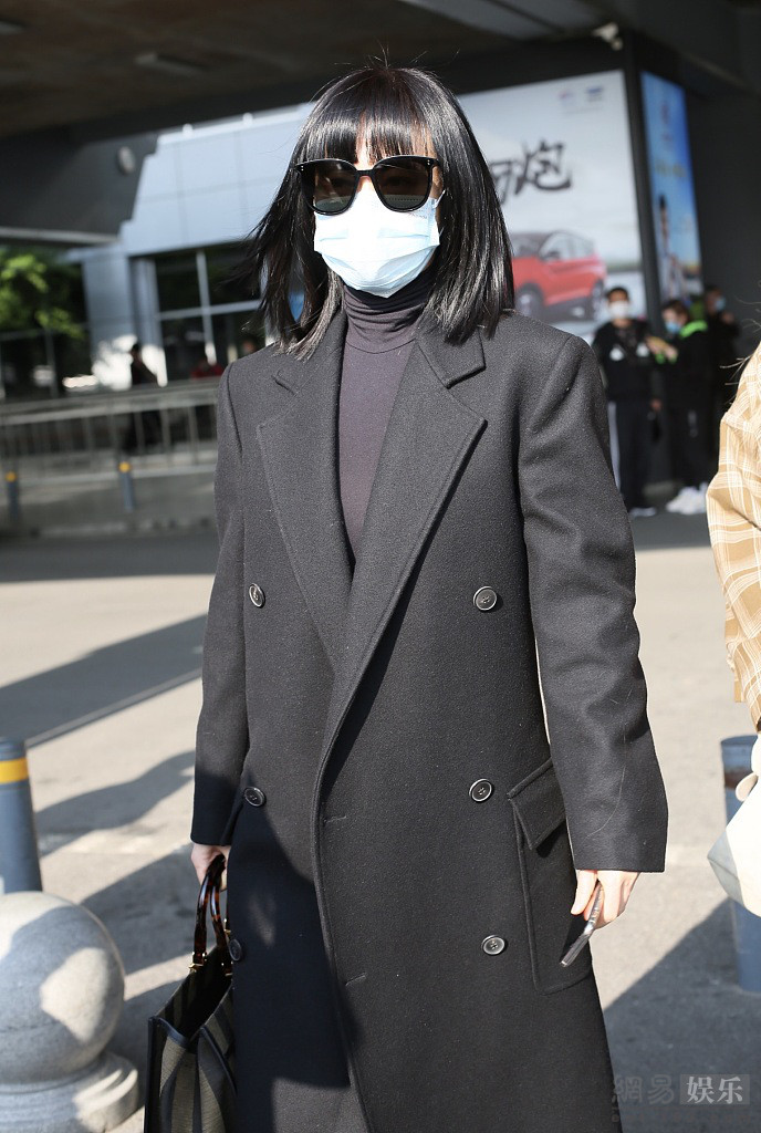 谭卓穿黑色风衣气场十足 机场获粉丝送花心情好