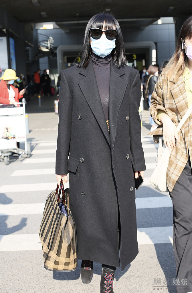 谭卓穿黑色风衣气场十足 机场获粉丝送花心情好