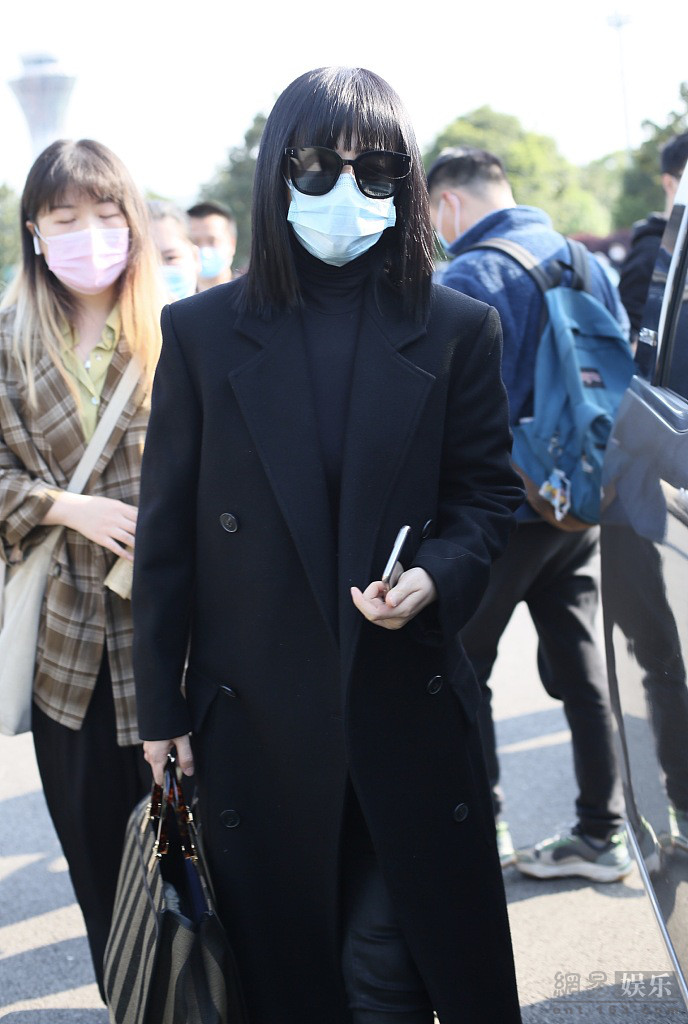 谭卓穿黑色风衣气场十足 机场获粉丝送花心情好