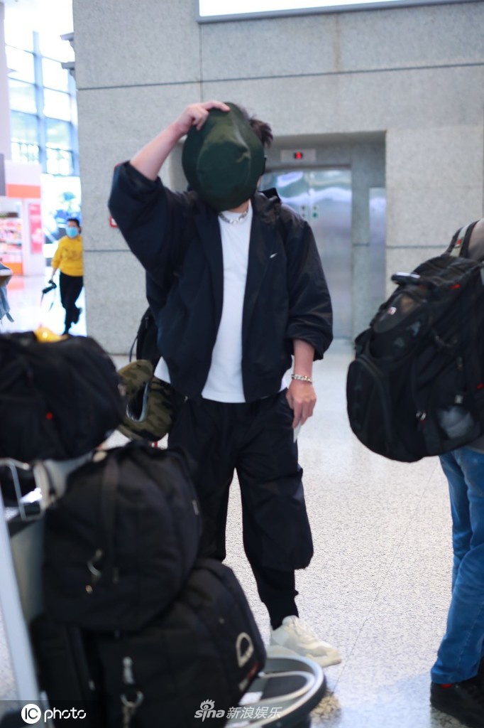 钱枫穿一身黑衣现身机场 高举帽子遮脸防止被拍