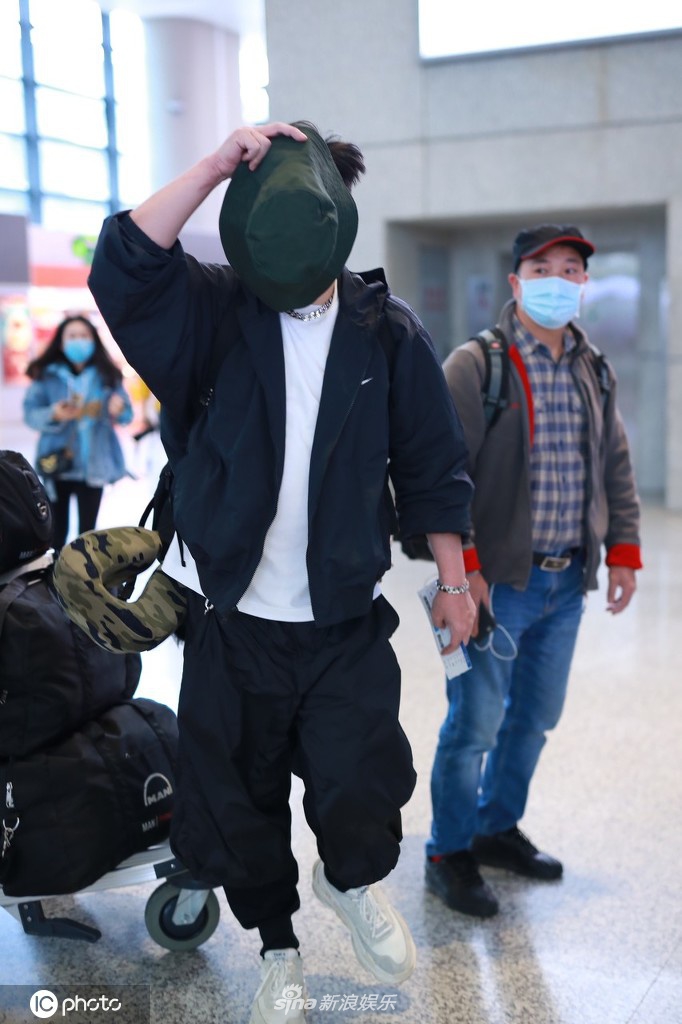 钱枫穿一身黑衣现身机场 高举帽子遮脸防止被拍