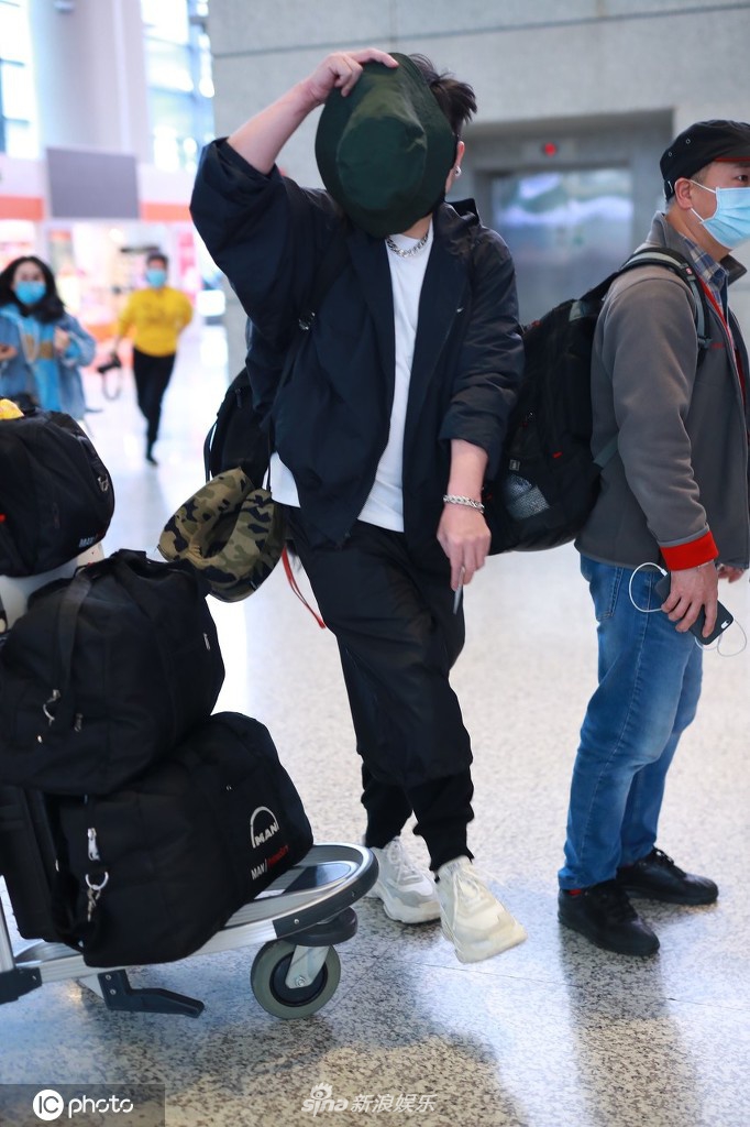 钱枫穿一身黑衣现身机场 高举帽子遮脸防止被拍