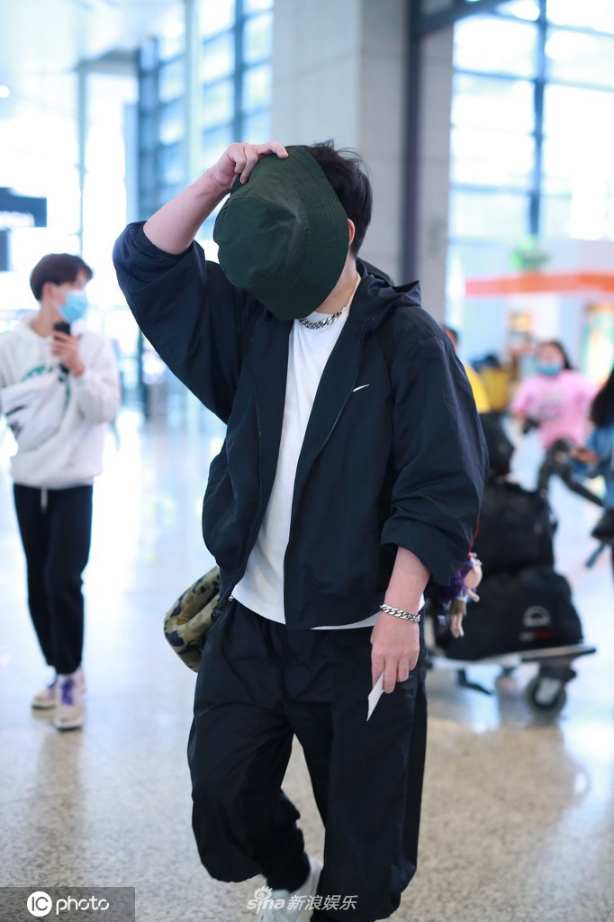 钱枫穿一身黑衣现身机场 高举帽子遮脸防止被拍
