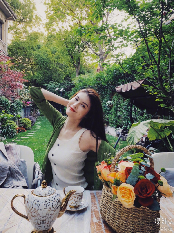 何穗分享春日穿搭 着绿色开衫置身花园清新悠闲