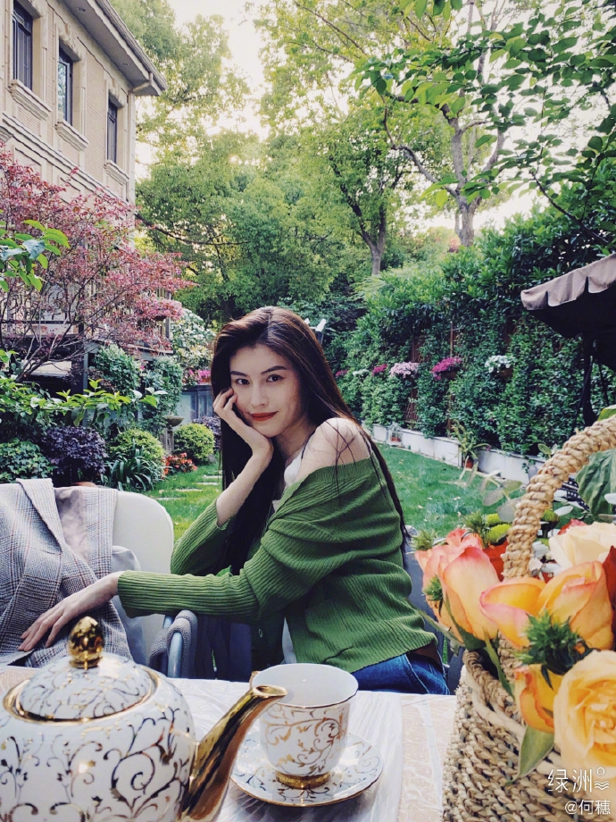 何穗分享春日穿搭 着绿色开衫置身花园清新悠闲