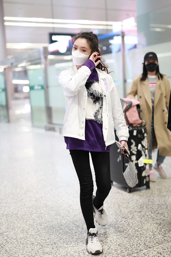 林允穿紫色T恤现身机场 蹲地系鞋带十分接地气