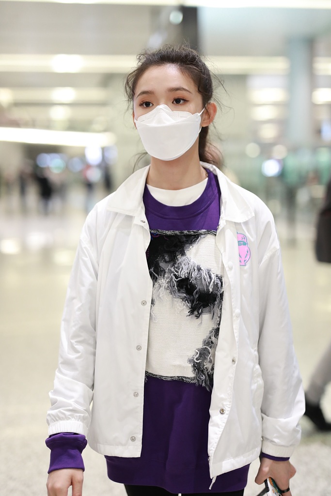林允穿紫色T恤现身机场 蹲地系鞋带十分接地气