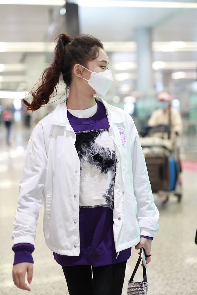 林允穿紫色T恤现身机场 蹲地系鞋带十分接地气