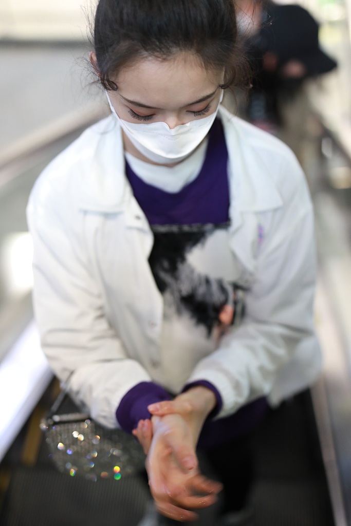 林允穿紫色T恤现身机场 蹲地系鞋带十分接地气