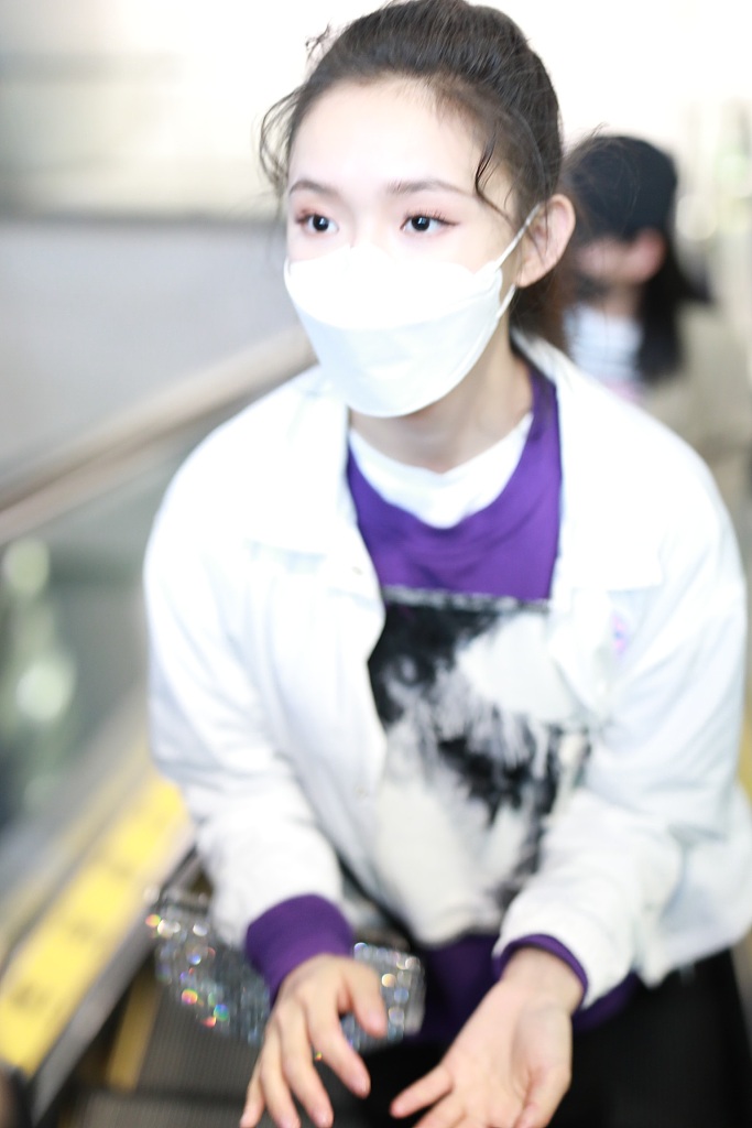 林允穿紫色T恤现身机场 蹲地系鞋带十分接地气