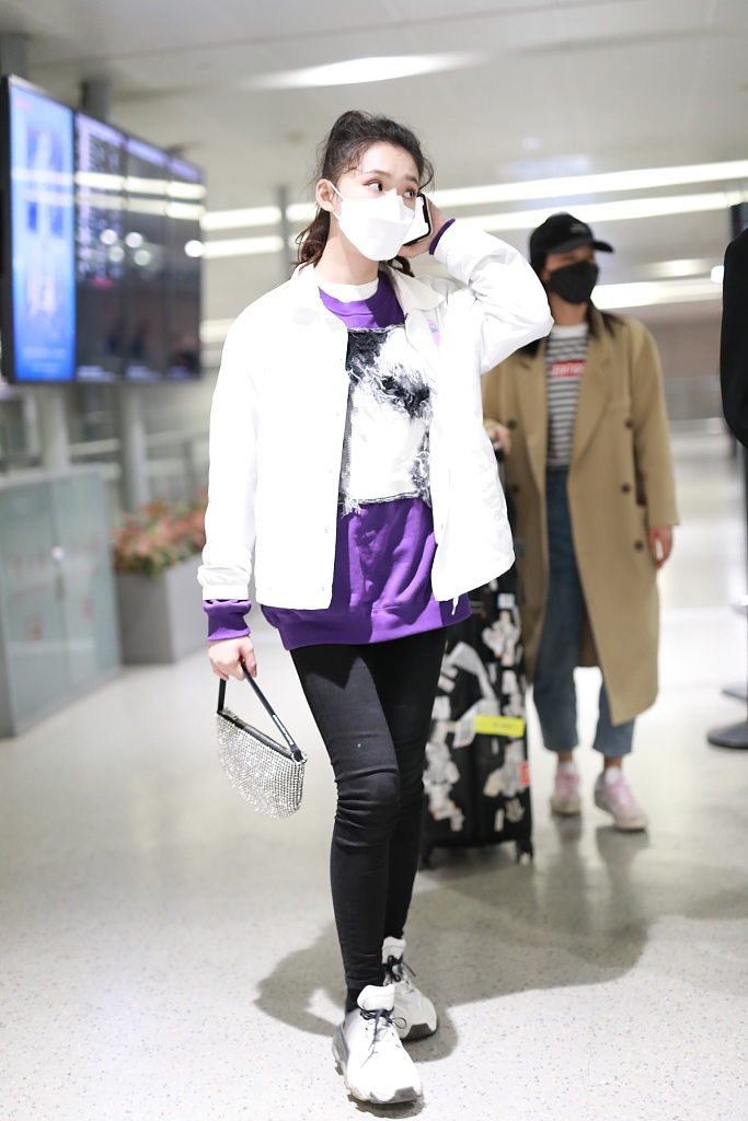 林允穿紫色T恤现身机场 蹲地系鞋带十分接地气
