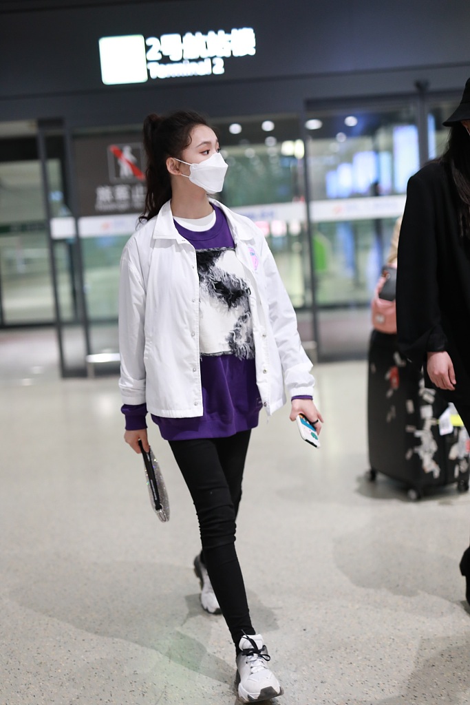 林允穿紫色T恤现身机场 蹲地系鞋带十分接地气