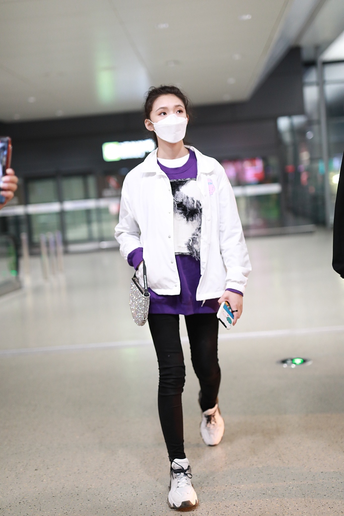 林允穿紫色T恤现身机场 蹲地系鞋带十分接地气