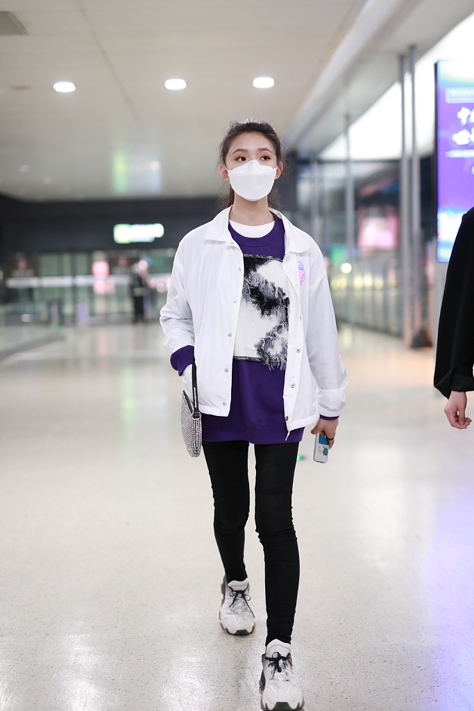 林允穿紫色T恤现身机场 蹲地系鞋带十分接地气