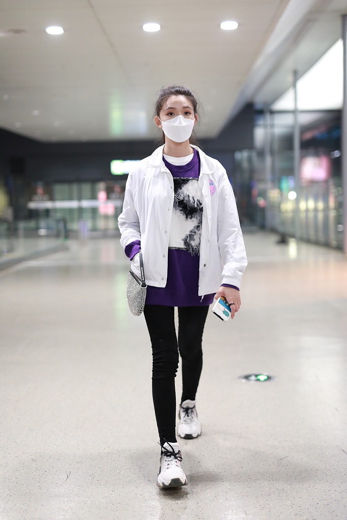 林允穿紫色T恤现身机场 蹲地系鞋带十分接地气
