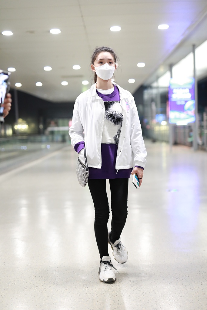 林允穿紫色T恤现身机场 蹲地系鞋带十分接地气