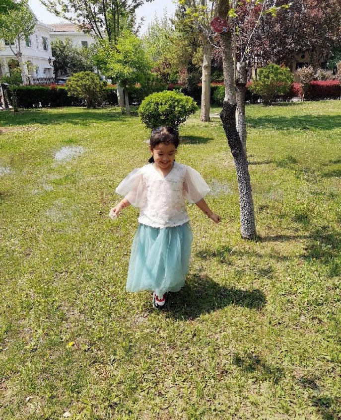 包文婧分享女儿春日萌照 饺子穿纱裙草坪玩耍俏皮可爱